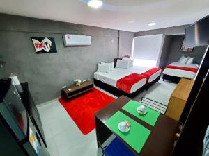 圣克鲁斯Bellini Suites Apartments的小房间设有两张床和红色地毯