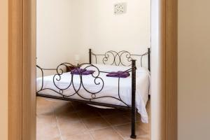 诺托玛丽娜~ Villa Demetra ~的一间卧室配有一张带白色床单和紫色弓的床