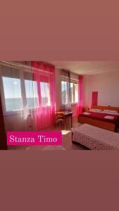 弗拉穆拉波拉德尔莱万特旅馆的一间卧室配有粉红色窗帘、一张床和一张桌子