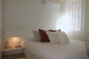 布拉加Sweet Dreams in Braga的白色的床、白色枕头和窗户