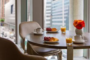 纽约Courtyard New York Manhattan/Midtown West的一张桌子,上面有早餐食品,放在一个窗口的房间