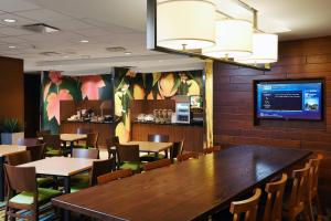 奥马哈Fairfield Inn & Suites by Marriott Omaha West的一间带桌椅和电视的用餐室