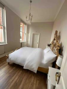 齐格威尔Luxury 2 BD, 2 BA on private gated Chigwell park的卧室配有一张白色的大床,铺有木地板
