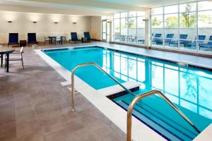 哥伦布SpringHill Suites by Marriott Columbus Easton Area的一座配有桌椅的酒店游泳池