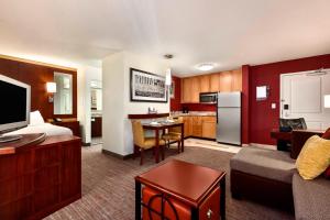 格林斯伯勒Residence Inn by Marriott Greensboro Airport的酒店客房设有厨房和客厅。