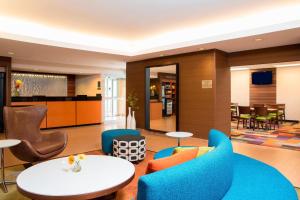 布卢明顿Fairfield Inn & Suites by Marriott Bloomington的酒店大堂设有蓝色椅子和桌子