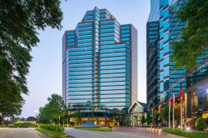 亚特兰大亚特兰大巴克海特JW万豪酒店的一座高大的建筑,有蓝色的窗户,位于城市