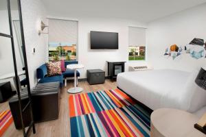 佛罗伦萨Aloft Florence的酒店客房,配有床和色彩缤纷的地毯