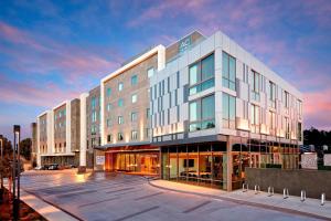 森尼维耳市AC Hotel by Marriott Sunnyvale Cupertino的一座大型建筑,前面设有停车场