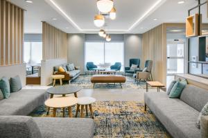 奥康诺摩沃TownePlace Suites by Marriott Oconomowoc的大堂配有沙发和桌椅