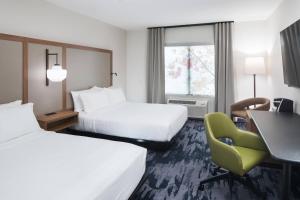 文特沃思港Fairfield Inn & Suites by Marriott Savannah I-95 North的酒店客房 - 带两张床、一张桌子和一把椅子
