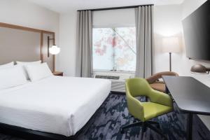 文特沃思港Fairfield Inn & Suites by Marriott Savannah I-95 North的酒店客房配有一张床、一张桌子和一把椅子。