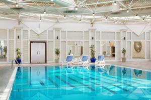 利雅德利雅得喜来登酒店的一座拥有蓝色水和蓝色椅子的游泳池