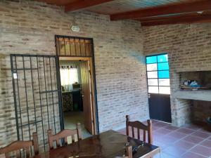 富内斯CASA EN FUNES的配有桌椅和砖墙的房间