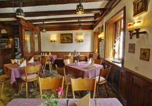 巴特迪尔海姆罗思勒酒店的一间餐厅,房间内设有紫色的桌椅