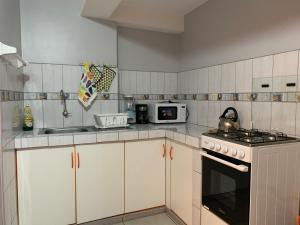 库斯科El Viejo Roble的厨房配有白色橱柜和炉灶烤箱。