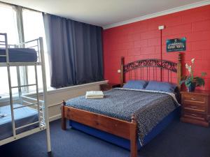 阿德莱德阿德莱德港背包客旅舍的一间卧室配有一张红色墙壁的床