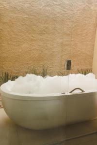 戈亚斯州上帕莱索Pousada Paraiso的浴室内设有一个白色浴缸