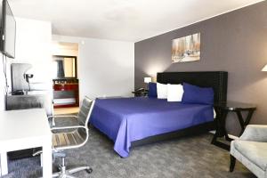 阿林顿R Nite Star Inn and Suites -Home of the Cowboys & Rangers的酒店客房配有床、桌子和沙发。