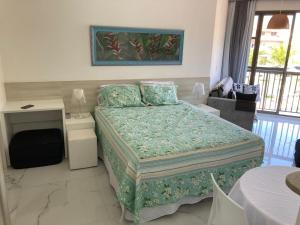 曼加拉蒂巴apartamento na Reserva do Sahy em Mangaratiba RJ的一间卧室配有一张床、一张书桌和一个窗户。