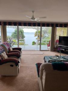 旺阿雷Tamaterau Seaview House in Whangarei的带沙发的客厅,享有海景