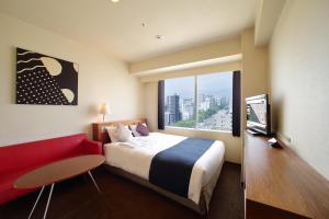 广岛广岛东方酒店的酒店客房,配有一张床和一张红色的沙发