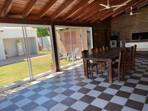 拉班达Hermosa Casa con Quincho y pileta的一个带桌椅的庭院,位于一个格子楼层