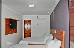 费拉迪圣安娜Hotel Center的一间卧室设有两张床和木制床头板