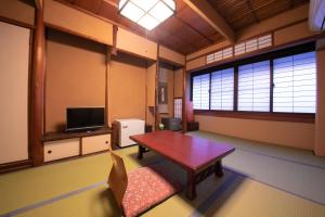 京都欧哈纳博的客厅配有桌子和电视