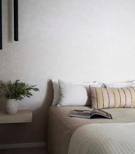 麦夸里港Tallowwood House Luxury Bed & Breakfast的一间卧室配有一张床,上面有一本书