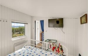 班霍尔姆1 Bedroom Beautiful Home In Bandholm的卧室配有一张床,墙上配有电视。