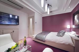 东京HOTEL REFRAIN的一间卧室配有一张床、一张桌子和一台电视。