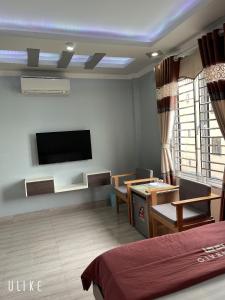 吉婆岛卡巴中央民宿的一间设有床铺和墙上电视的房间