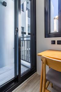 垦丁大街垦丁海堤112海景别墅的客房设有桌子和带阳台的玻璃门