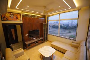 阿格拉Taj Sojourn的带沙发和大窗户的客厅