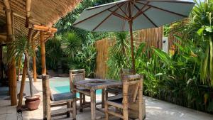 吉利阿尔Gilipad Villa的游泳池旁遮阳伞下的桌椅