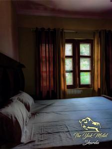 锡卡都The Yak Motel的一间卧室设有一张大床和窗户