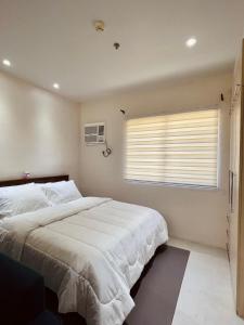 达沃市Studio Type - Matina Enclaves Residences的卧室设有一张白色大床和一扇窗户。