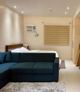 达沃市Studio Type - Matina Enclaves Residences的客厅配有蓝色的沙发和床。