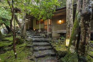 奈良月日亭酒店的通往树木房屋的石头路