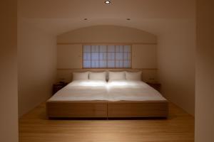 奈良月日亭酒店的一间卧室配有一张带白色床单的床和一扇窗户。