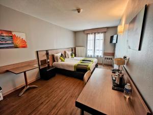 里昂里昂中心舒适套房左岸酒店的配有一张床和一张书桌的酒店客房