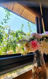金湖镇金门十美渡假村的花瓶装满鲜花,坐在窗户里