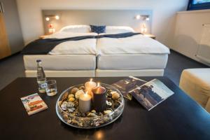 布拉迪斯拉发Felicity Garni Hotel的一间设有一张床和一张带蜡烛的桌子的房间
