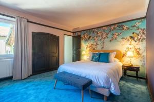 普罗旺斯地区萨隆La Maison d'été的一间卧室配有一张带花卉壁纸的大床