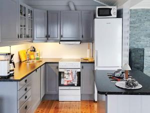 TengelfjordenHoliday Home Raften的厨房配有灰色橱柜和白色冰箱