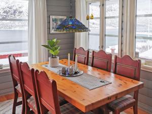 TengelfjordenHoliday Home Raften的用餐室配有带红色椅子的木桌