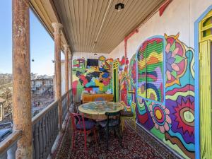 第比利斯礼遇旅舍的阳台配有桌椅和色彩缤纷的墙壁。