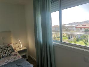 莫阿尼亚Apartamento Gran Terraza的一间卧室设有一张床和一个大窗户