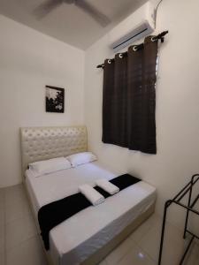 淡马鲁Homestay Temerloh Near Hospital Wi-Fi Netflix的一间卧室配有一张带黑色窗帘的床